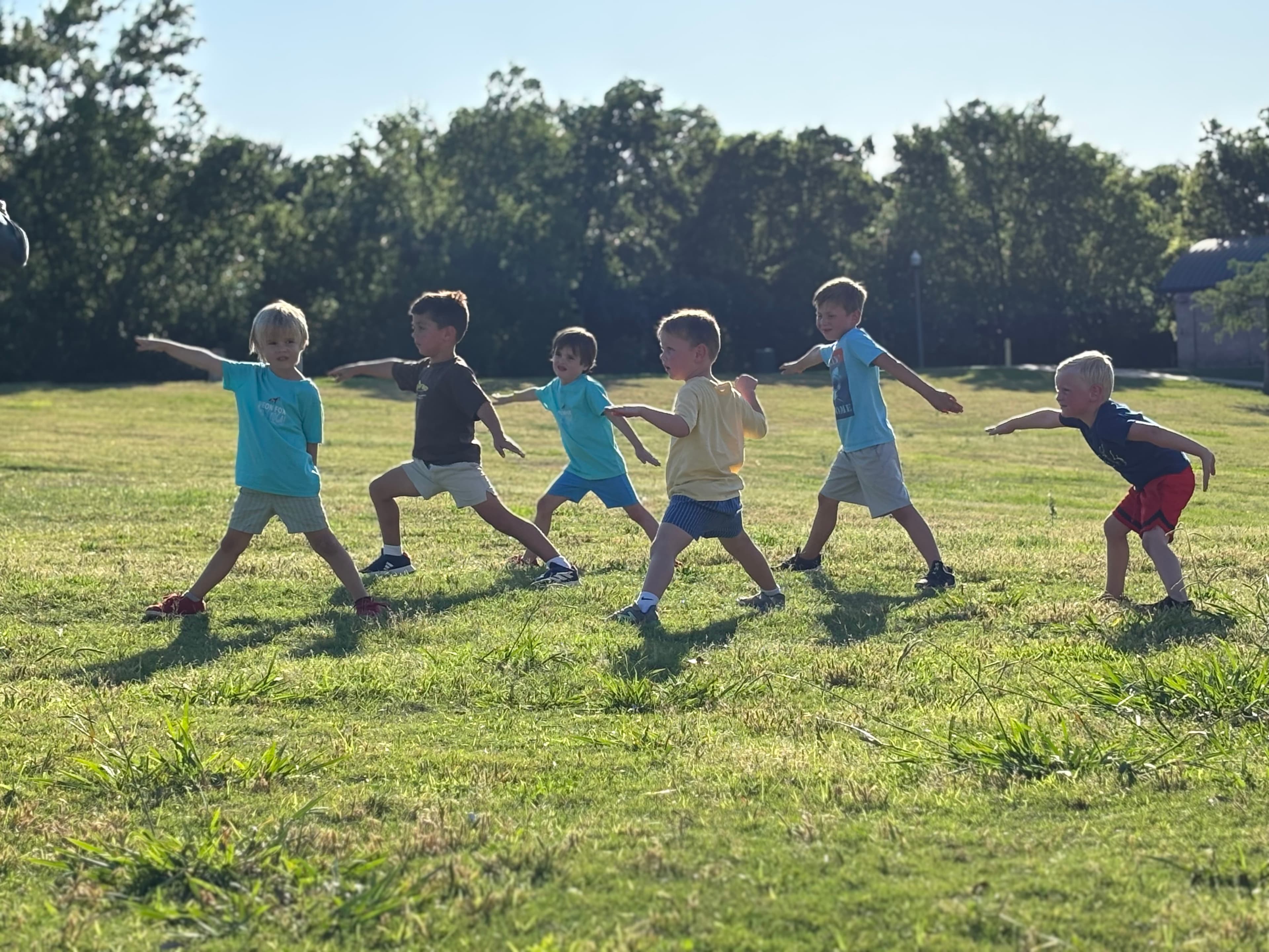 Kids doing warrior pose outdoors at Wolf Pen Creek